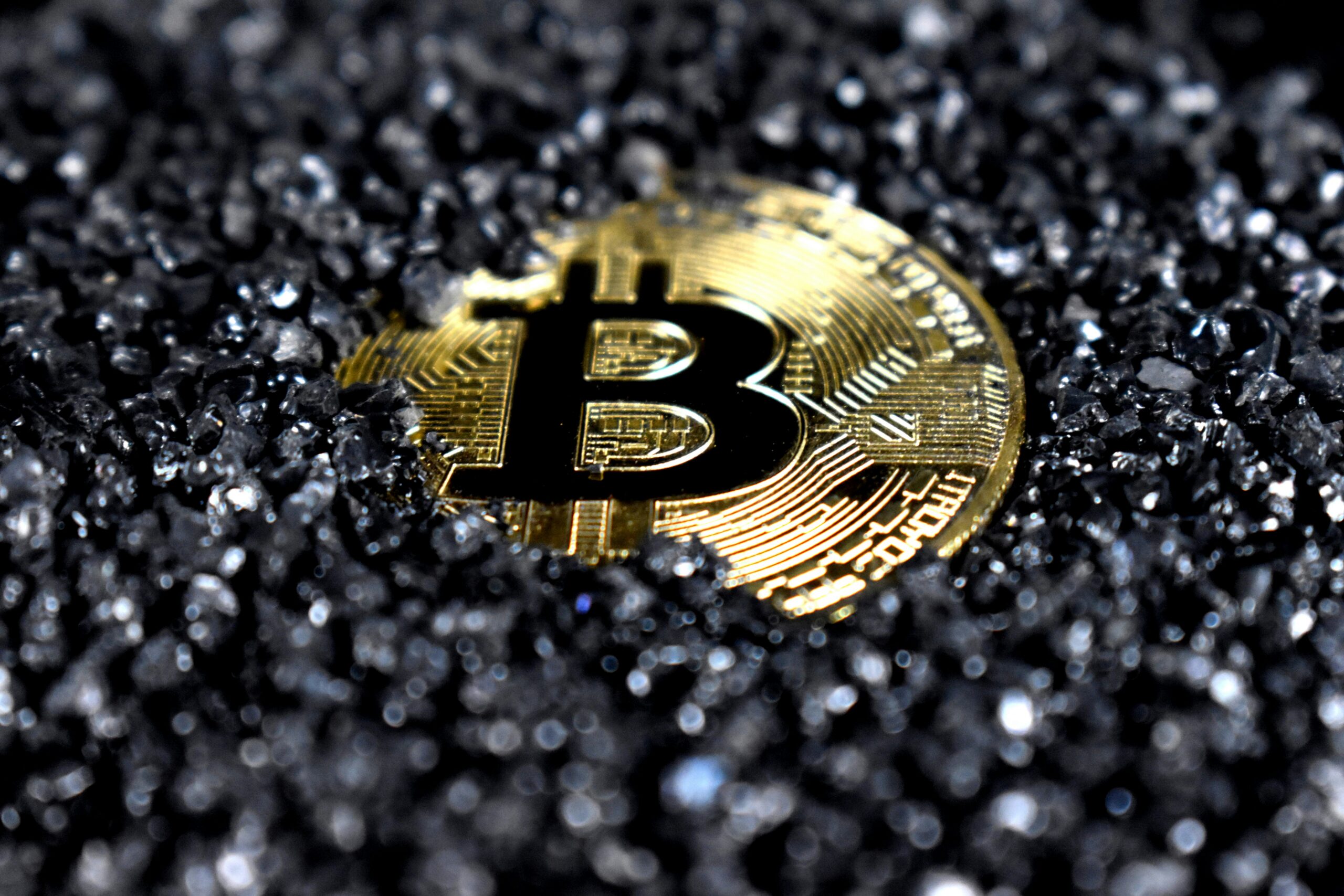 Why is Bitcoin going up: a Bitcoin coin on black sand